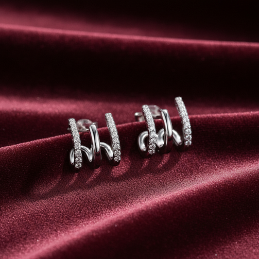 arcana three-layer sterling silver earrings with sparkling gem accents on a deep red velvet background