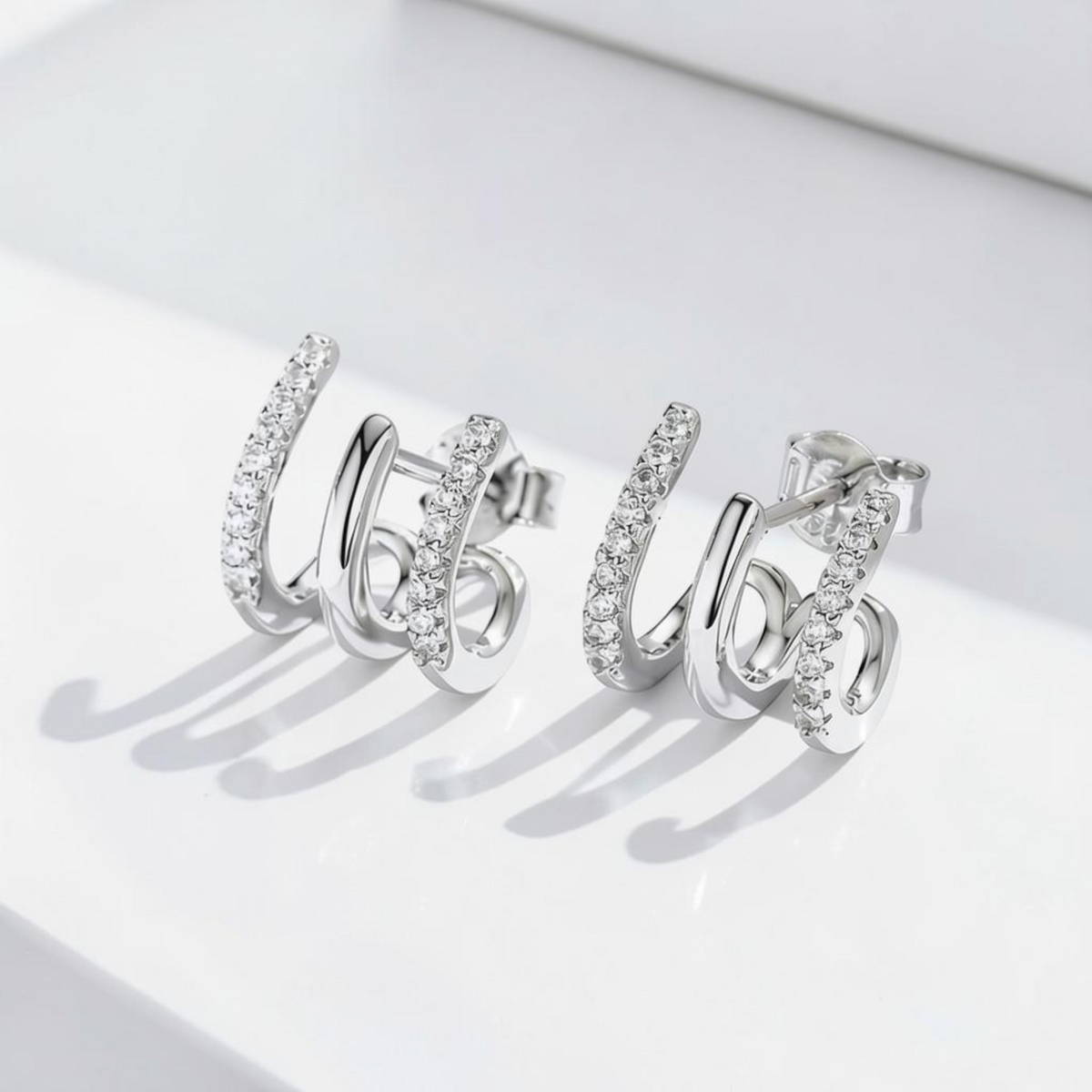 arcana three-layer heart-shaped sterling silver earrings with sparkling gem accents on a white background